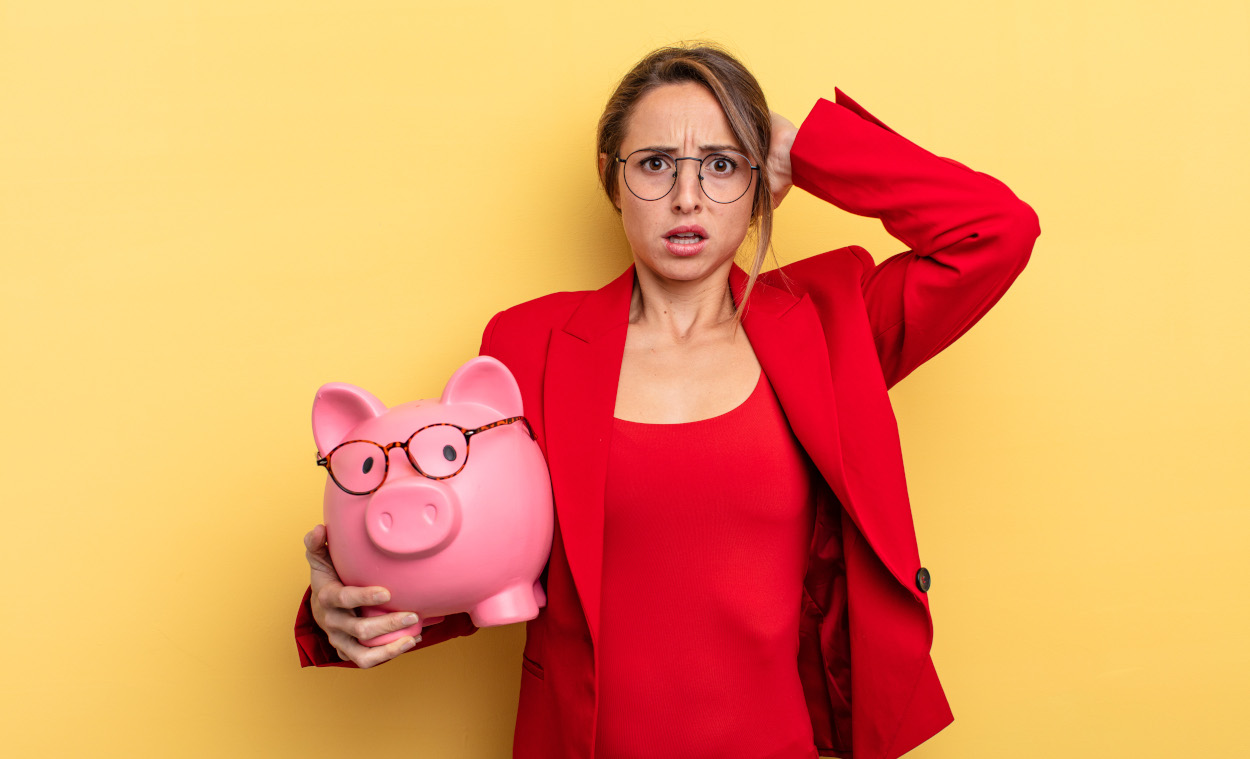 stressed business woman holding a piggy bank