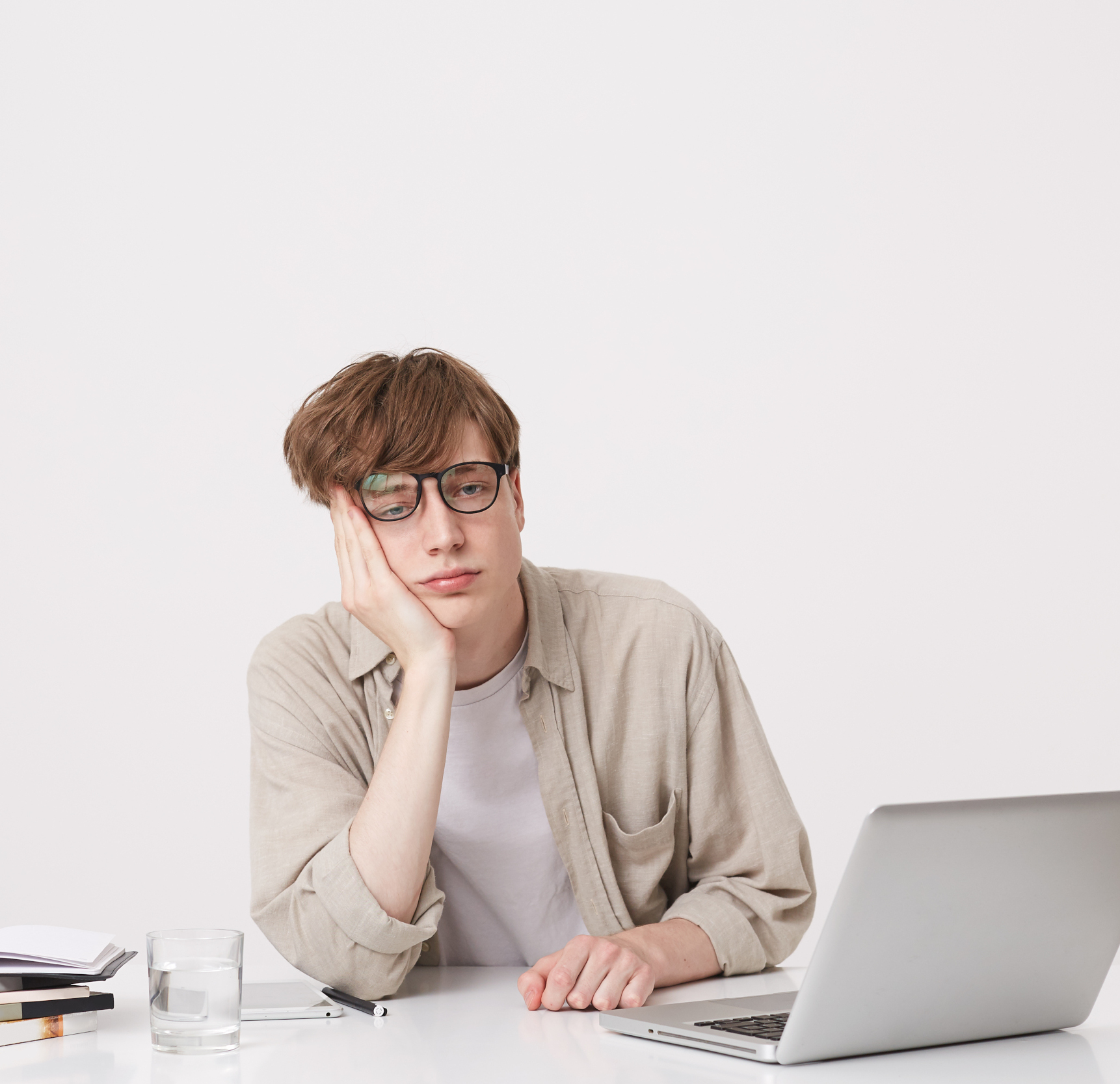 depressed man wearing beige shirt sitting in front of a beige wall